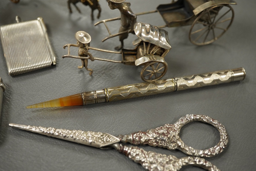 Sundry small silver and other items including a pig pin cushion, Adie & Lovekin, Birmingham, 1906, 45mm, a silver circular stamp case, a silver vesta case, a small sterling mounted notecase, three small metal rickshaws,